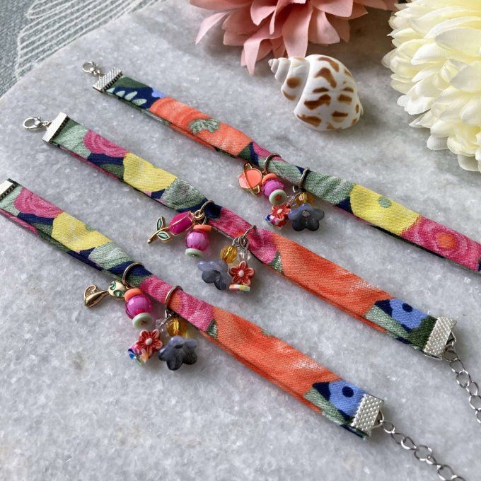 Bracelet en tissu fleuri bleu foncé, orange, rose et jaune à breloques